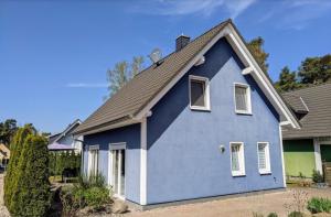 a blue house with a gray roof at Unter den Kiefern 62 in Röbel