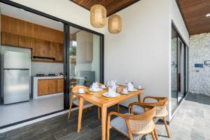 a kitchen and dining room with a wooden table and chairs at Diwangkara Villa Pandawa in Ungasan