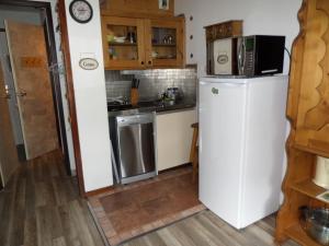 a small kitchen with a refrigerator and a microwave at Appartement Les Glieres in Bourg-Saint-Maurice