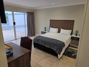 Un dormitorio con una cama y un escritorio y una ventana. en THE SEA BREEZE GUEST HOUSE & VENUE HIRE, 11 on SHELBOURNE, en Durban 74 fotos más