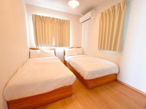 ein kleines Zimmer mit zwei Betten und einem Fenster in der Unterkunft In time tokyo in Ichikawa