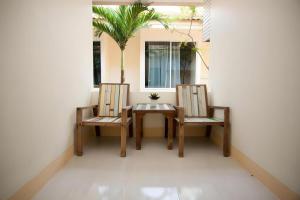 Lotusland Resort في جومتين بيتش: كرسيين وطاولة على الشرفة