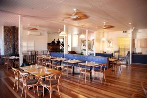 ein Restaurant mit Tischen und Stühlen und Menschen im Hintergrund in der Unterkunft Commercial Hotel Boonah in Boonah