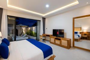 a bedroom with a king sized bed and a television at Diwangkara Villa Pandawa in Ungasan