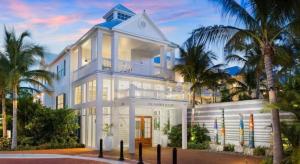 a white house with palm trees in front of it at The Marker Key West Harbor Resort in Key West