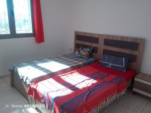 Appartement 5 Midoun centre في تاجورميس: غرفة نوم بسرير وبطانية حمراء وزرقاء