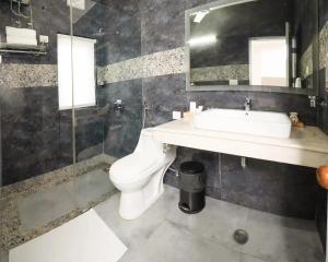 BedChambers Suites Near Sector 29, Gurgaon في جورجاون: حمام مع حوض ومرحاض