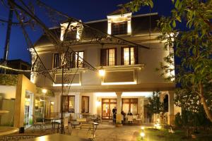 a large white house with a patio at night at Hotel Green Garden in Shumen