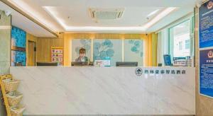 a counter in a store with a woman in the background at GreenTree Inn Beijing Capital Airport New International Exhibition Center Express Hotel in Beijing