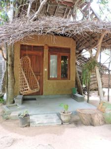 una pequeña casa con puerta y ventana en Cinnabar Resort, en Tangalle