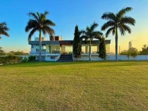 a house with palm trees in front of a field at Takery Resort in Chittaurgarh