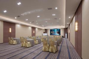 a conference room with chairs and tables and a screen at T Social Hotel Guangzhou Railway Station Branch in Guangzhou