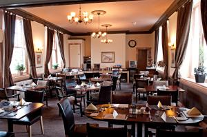 a restaurant with wooden tables and chairs and windows at The Black Bull inn in Wooler