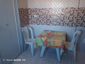 Appartement 5 Midoun centre في تاجورميس: طاولة عليها كرسيين وطاولة عليها لحاف