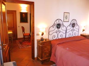 a bedroom with a bed with a red bedspread at Locanda Di Villa Torraccia in La Torraccia