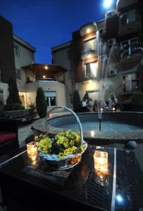 Una cesta de comida en una mesa con luces encendidas. en Apartments Iwa Centar, en Vrnjačka Banja