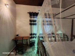 a bedroom with a canopy bed with a table and a tableablish at Hilltop Haven in Mirissa