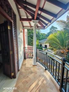 un balcón de una casa con barandilla en Hilltop Haven, en Mirissa