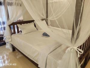 a bed with mosquito netting in a room at Hilltop Haven in Mirissa