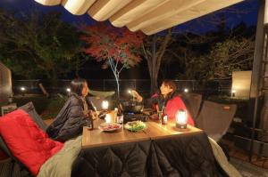 two women sitting at a table at night at SEN RETREAT CHIKATSUYU - Kumano Kodo Gateway in Tanabe