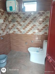 un bagno con un water e una tv a parete di Sanjh Savera Home stay a Dera Gopipur