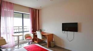 a hotel room with a bed and a desk and a television at Thank Inn Hotel Sichuan Normal University Chenglong Branch in Chengdu +93 photos