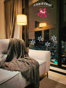 Una sala de estar con un cartel navideño en una ventana. en Urban Suites TWO Or THREE Bedroom Georgetown by ANC, en Jelutong