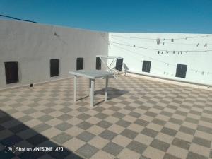 Appartement 5 Midoun centre في تاجورميس: طاولة بيضاء موضوعة فوق مبنى