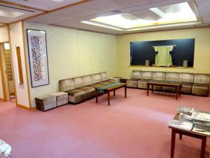 una sala de espera con sofás de cuero y TV en Azumaya Ryokan, en Kioto