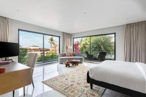 a bedroom with a bed and a desk and a couch at Amorzito by Solitaire Stays in Dona Paula