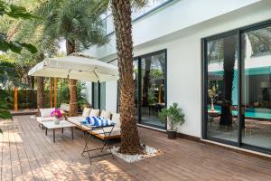 a patio with a table and an umbrella at Amorzito by Solitaire Stays in Dona Paula