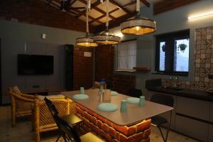 a dining room with a table with chairs and lights at The Loft -Aadhya Homestay Hampi in Munirābād