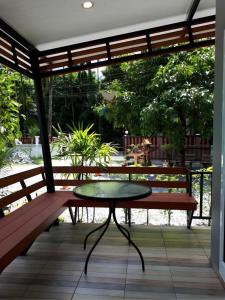 a table and two benches on a patio at Baan Bhuriwat Kiriwong in Khiriwong