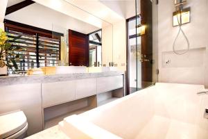 Luxury On The Bay - 2 x 3 bedroom apartments في خليج بايرون: حمام أبيض مع حوض ومرحاض +52 صورة