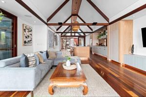 Luxury On The Bay - 2 x 3 bedroom apartments في خليج بايرون: غرفة معيشة مع أريكة وطاولة قهوة