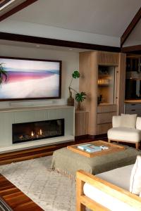a living room with a fireplace and a flat screen tv at Luxury On The Bay 1 in Byron Bay