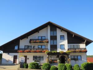 a large white building with flowers on the balconies at Büchelsteiner Hof in Grattersdorf