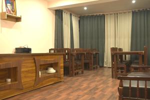 uma sala com mesas, cadeiras de madeira e cortinas em The Syia em Hundar mais 23 fotografias