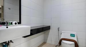 Un baño con lavabo, inodoro y espejo. en Sattahip 9 Boutique Hotel, en Sattahip 135 fotos más