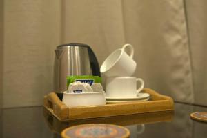uma bandeja de madeira com xícaras e pratos sobre uma mesa em The Syia em Hundar