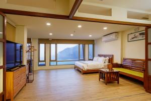 a bedroom with a bed and a large window at 隱山居 海景包棟2-10人 in Jiufen