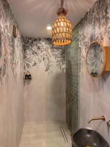 a bathroom with a shower with a sink and a chandelier at Boho Home in Veliko Tŭrnovo