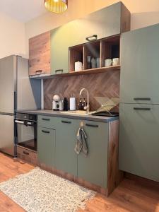 a kitchen with stainless steel appliances and wooden cabinets at Boho Home in Veliko Tŭrnovo