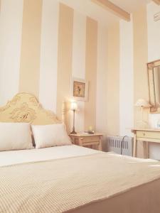 a bedroom with a large bed with striped walls at Molino La Boticaria in Marchena