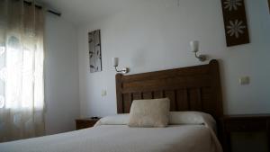 1 dormitorio con cama con almohada en Hostal Restaurante Bustos, en Villarrubio