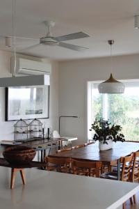 a dining room with tables and chairs and a ceiling fan at The Yanakie House & Cabins in Yanakie