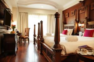 Una habitación de hotel con una cama grande y un escritorio. en JC Residency Madurai, en Madurai