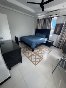 a bedroom with a bed and a desk in it at Villa de Sancho in Phumĭ Réach Born