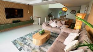 a living room with two couches and a table at Mali Villa 57 in Patong Beach