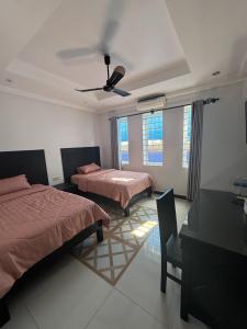 a bedroom with two beds and a ceiling fan at Villa de Sancho in Phumĭ Réach Born